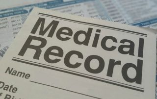 A medical record is sitting on top of a sheet of paper.