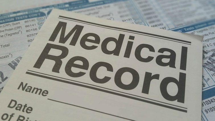 A medical record is sitting on top of a sheet of paper.