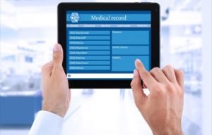 A man is holding a tablet with a medical record on it, showcasing his expertise in healthcare careers.