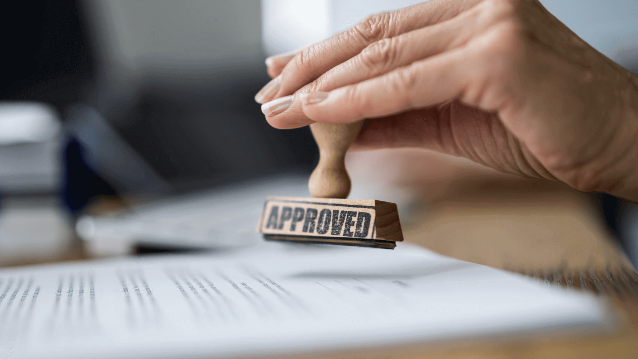A hand stamping the word CARF Accreditation on a piece of paper.