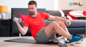 A man is sitting on the floor with dumbbells in his hands.