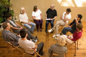 A group of people sitting in a circle, engaging in an addiction support session.
