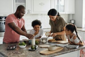 A family is cooking together in the kitchen, promoting children's mental health and fostering a sense of unity.